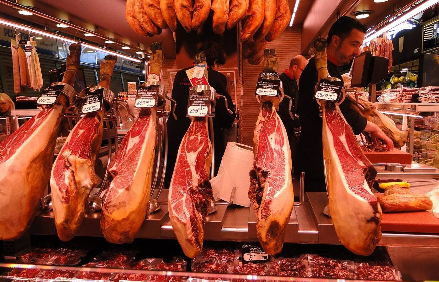 Jamones ibéricos colgados en un puesto de mercado